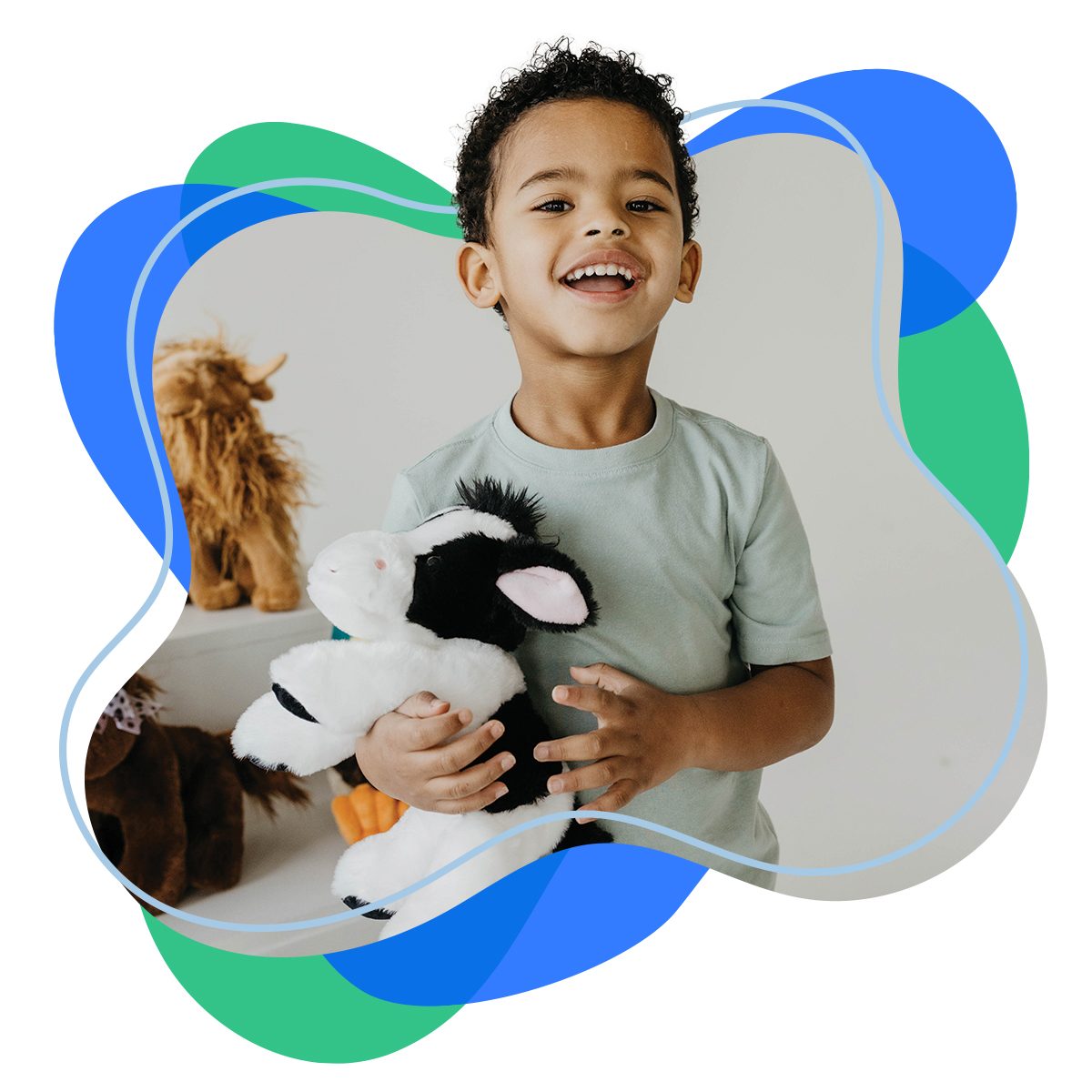 A boy holding a cow plush toy and a sheep plush toy