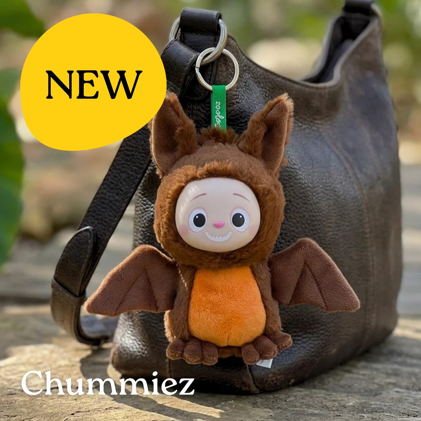 A brown Chummiez plush bag charm clipped to a backpack
