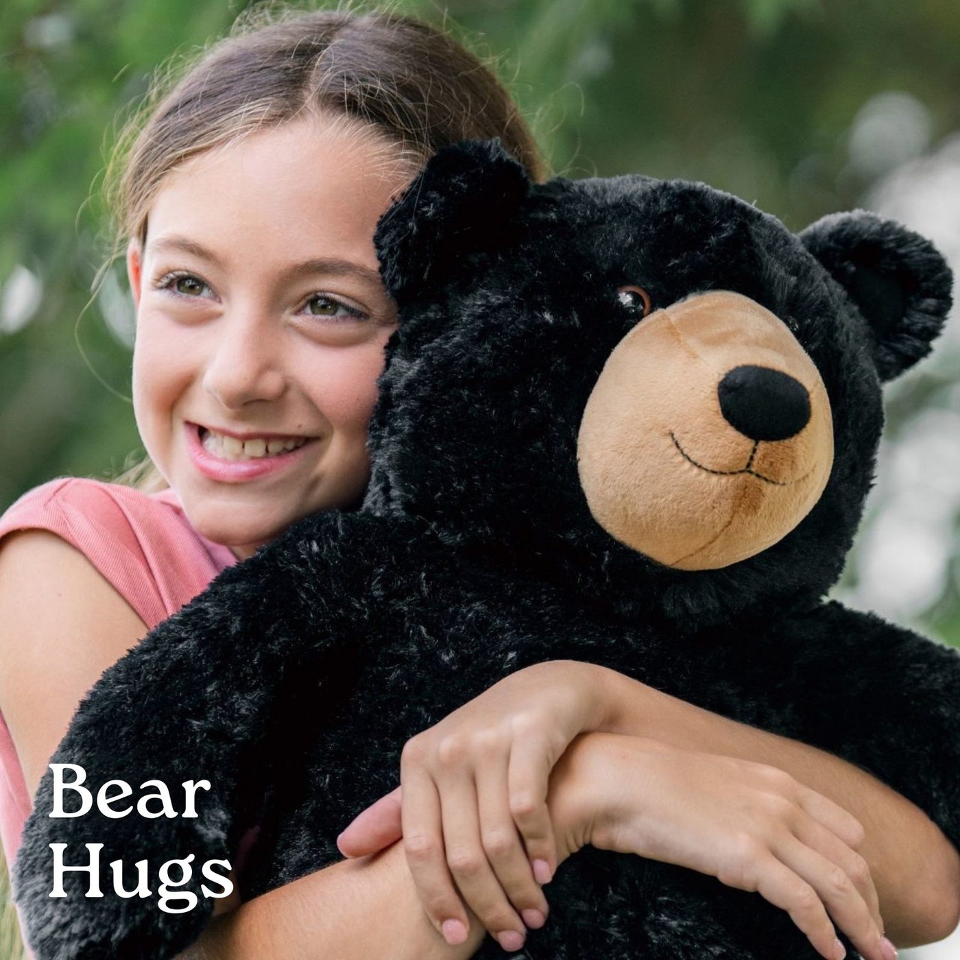 A girl hugging a large black bear plush toy