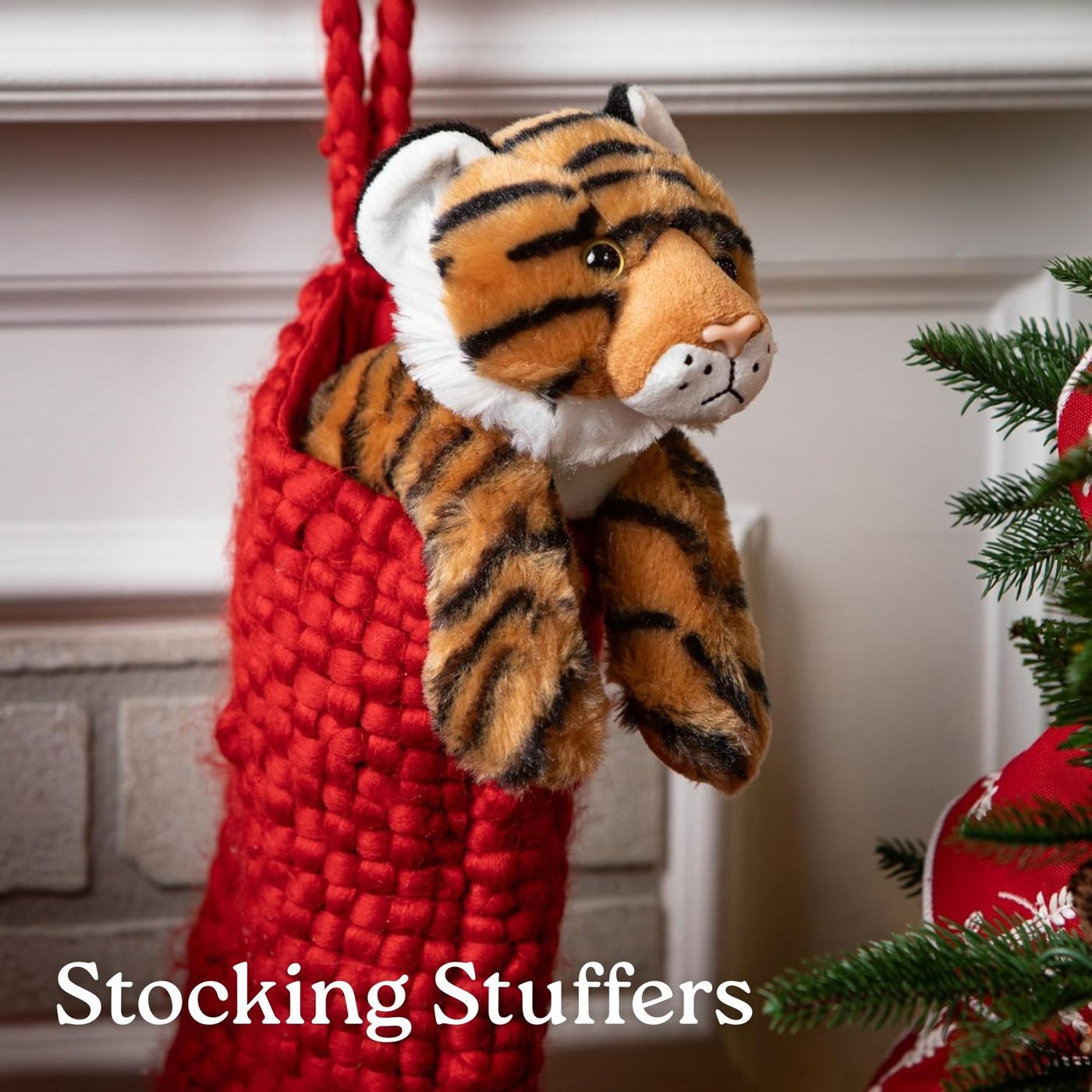 A tiger plush toy tucked into a Christmas stocking by the hearth